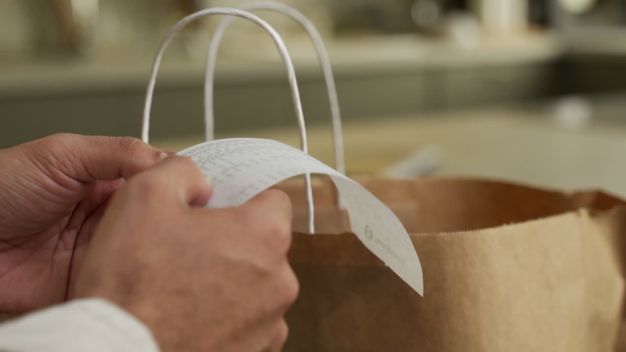 남자는 집에서 식료품 가게에서 쇼핑 후 수표를보고