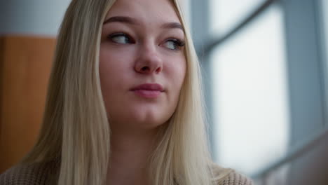 close-up of elegant lady sipping coffee with focus, looking at something thoughtfully while background softly blurred, capturing a moment of calm and contemplation
