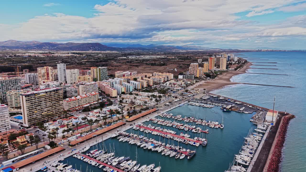 Kystudsigt over Spanien med bygninger og både nær kystlinjen