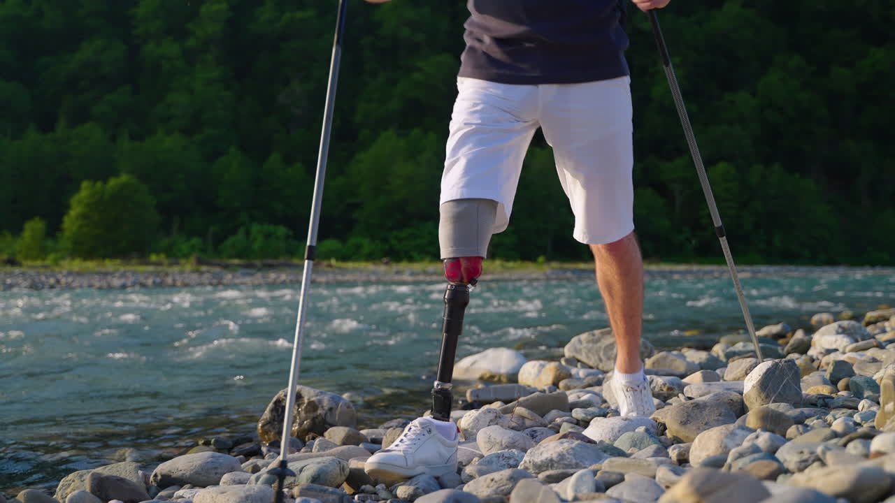 Man with prosthetic leg hiking by a river