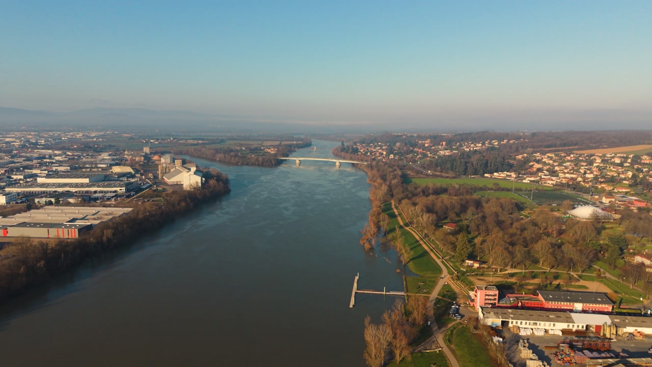 Villefranche-sur-Saone,Rhone,France flight crossing the River Saone showing extensive industrial estates on one bank and houses on the other,bridges and distant views in misty golden sun