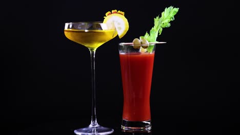 two cocktails elegantly arranged against a black background, highlighting vibrant colors and garnishes with dramatic lighting