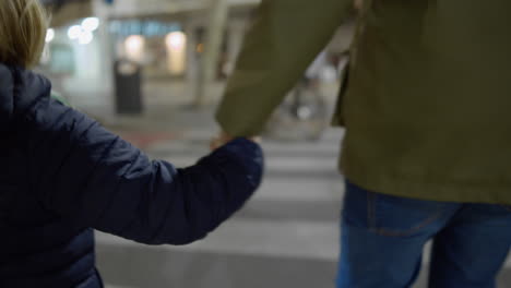 big brother and little sister walking across the road holding hands