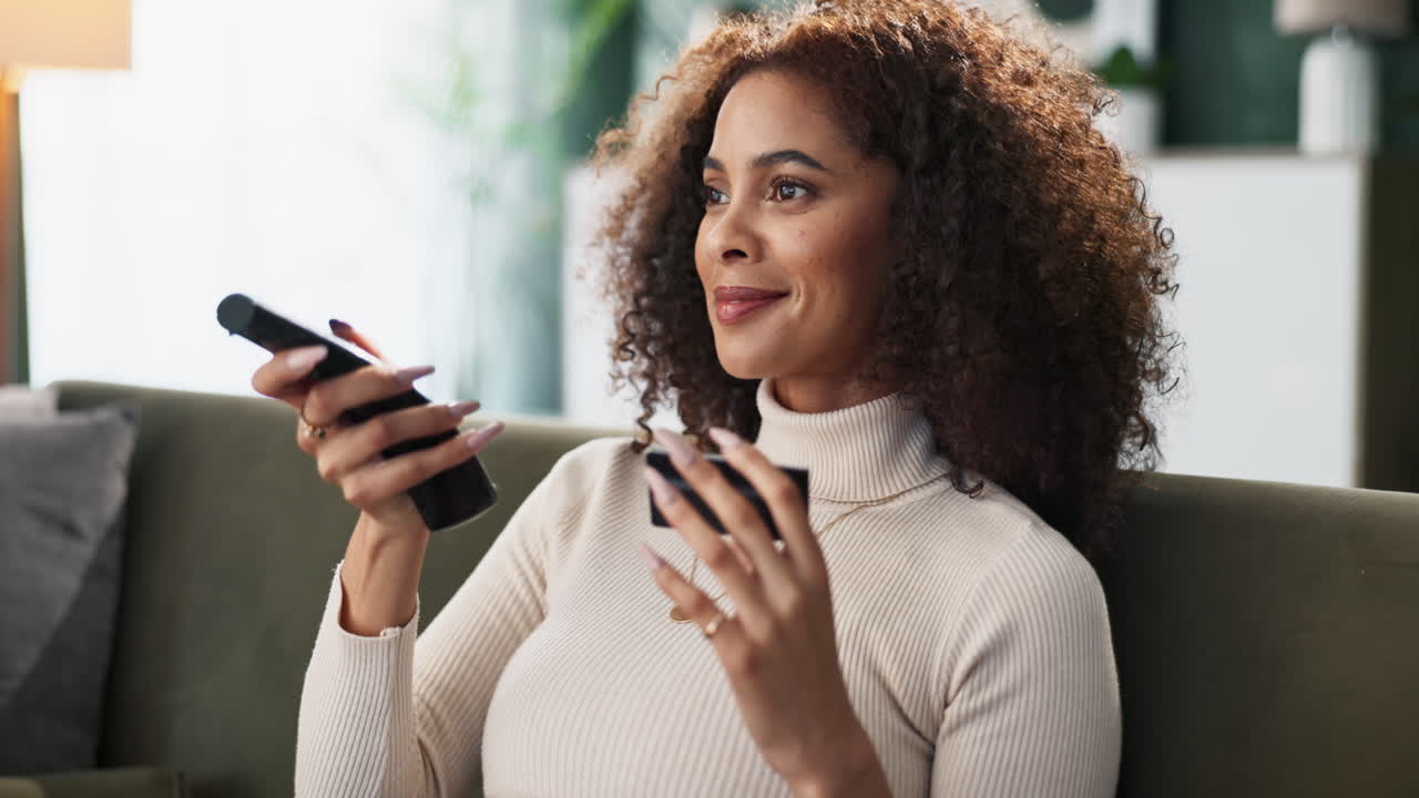 Woman on couch with remote control and credit card