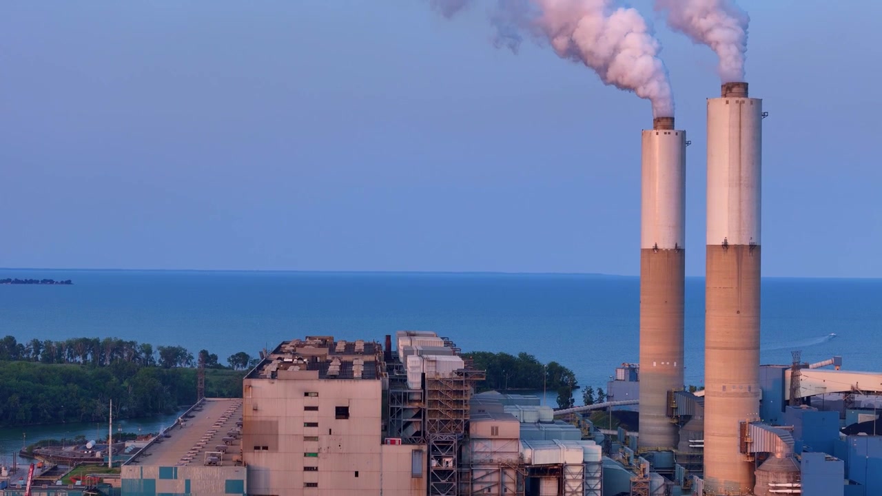 Monroe Coal Power Plant Chimneys Emitting Smoke on Lake Erie Shoreline - Aerial Establishing Shot
