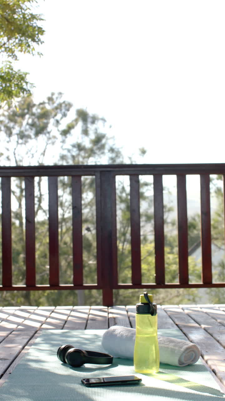 Slow-motion video captures water bottle, towel, headphones, smartphone on mat in cabin