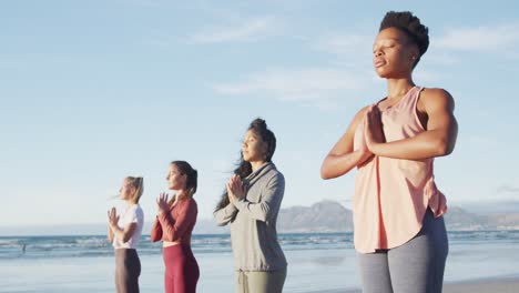 Gruppe-Verschiedener-Freundinnen,-Die-Yoga-Am-Strand-Praktizieren