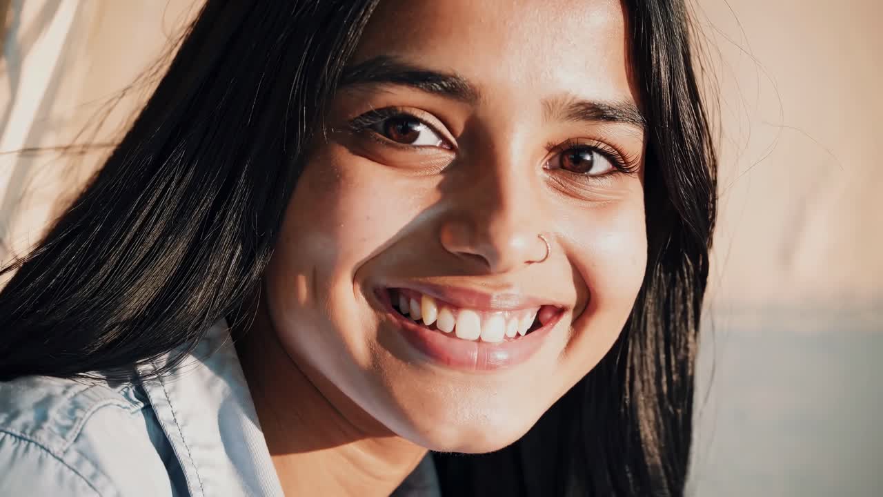 Close-up video still of a smiling woman with natural lighting