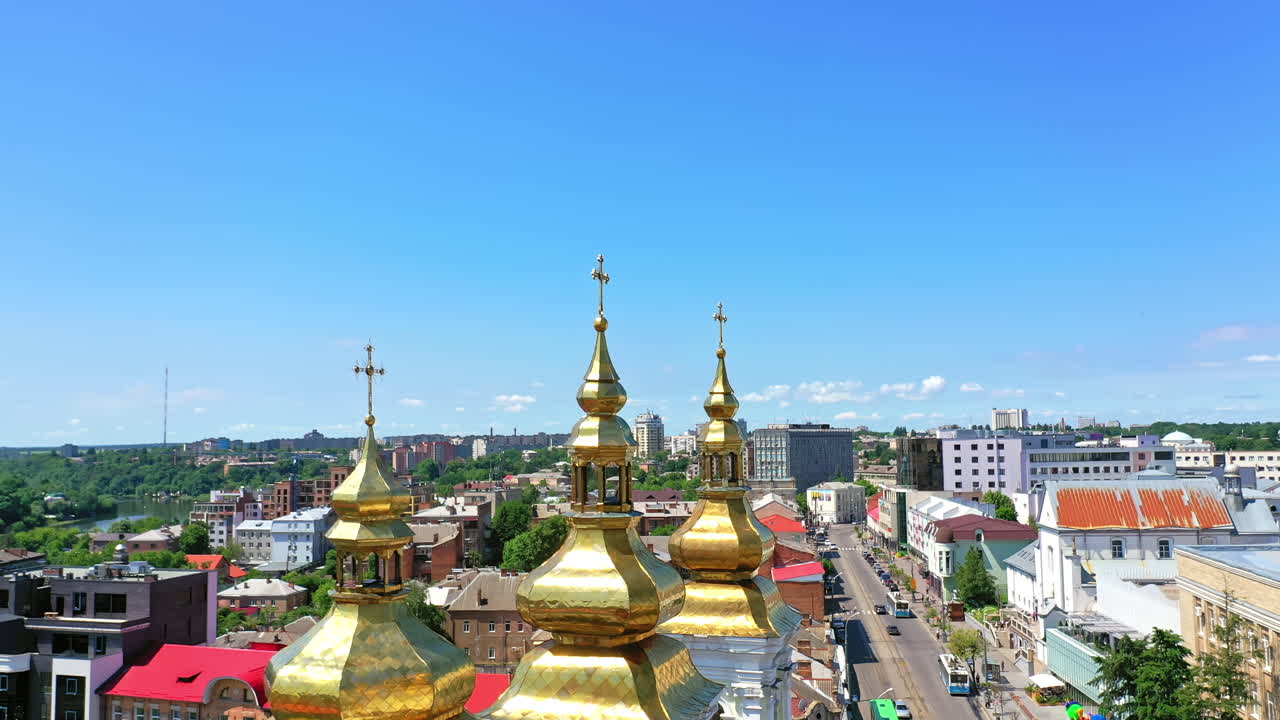 City view with beautiful cathedral in the centre. Golden cupolas with crosses at backdrop of blue clear sky.