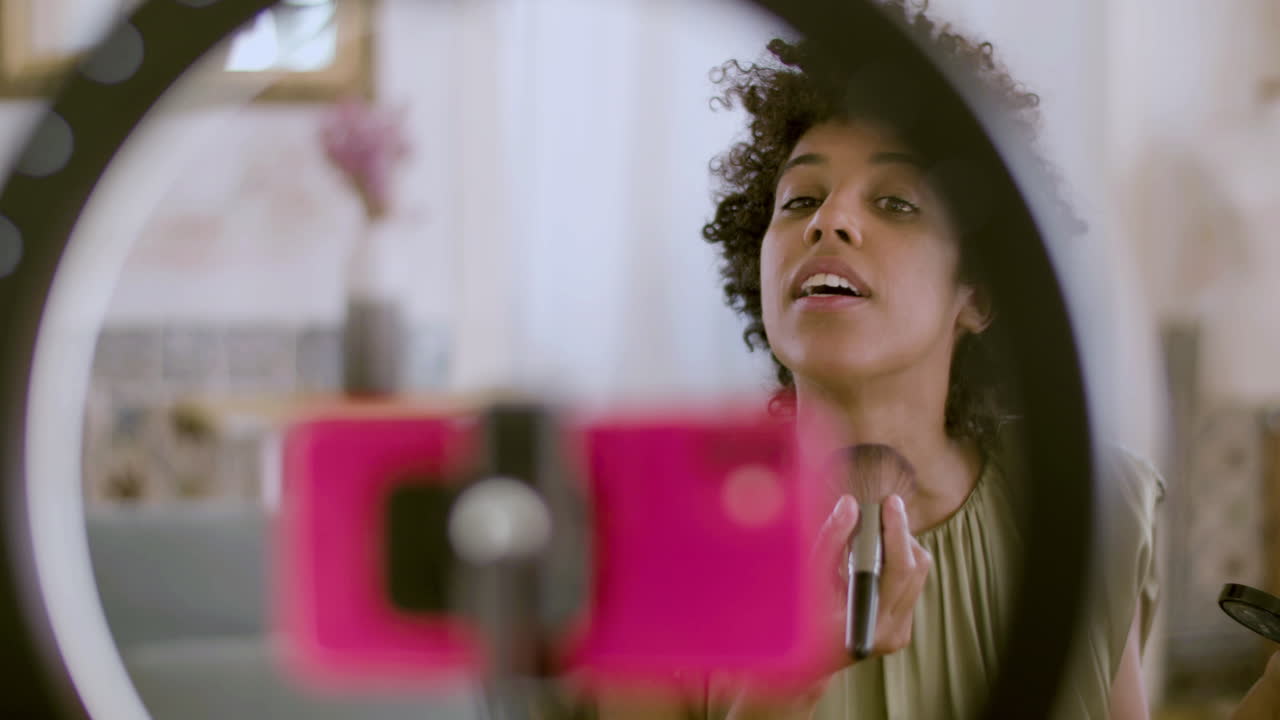 vloguera afroamericana transmitiendo tutorial de maquillaje para su vlog