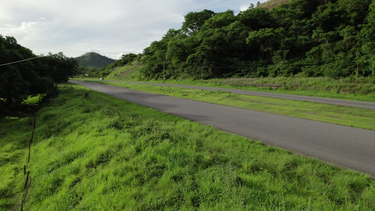 Aerial view of white truck on rural highway with green rolling hills. Food delivery concept
