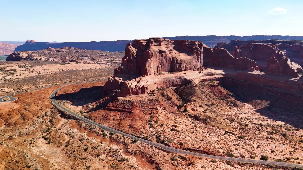 Fantastiske arkivopptak fra Arches nasjonalpark USA en lys ettermiddag. Det strålende sollyset belyser de majestetiske røde sandsteinsformasjonene og ørkenlandskapet under en klar blå himmel.