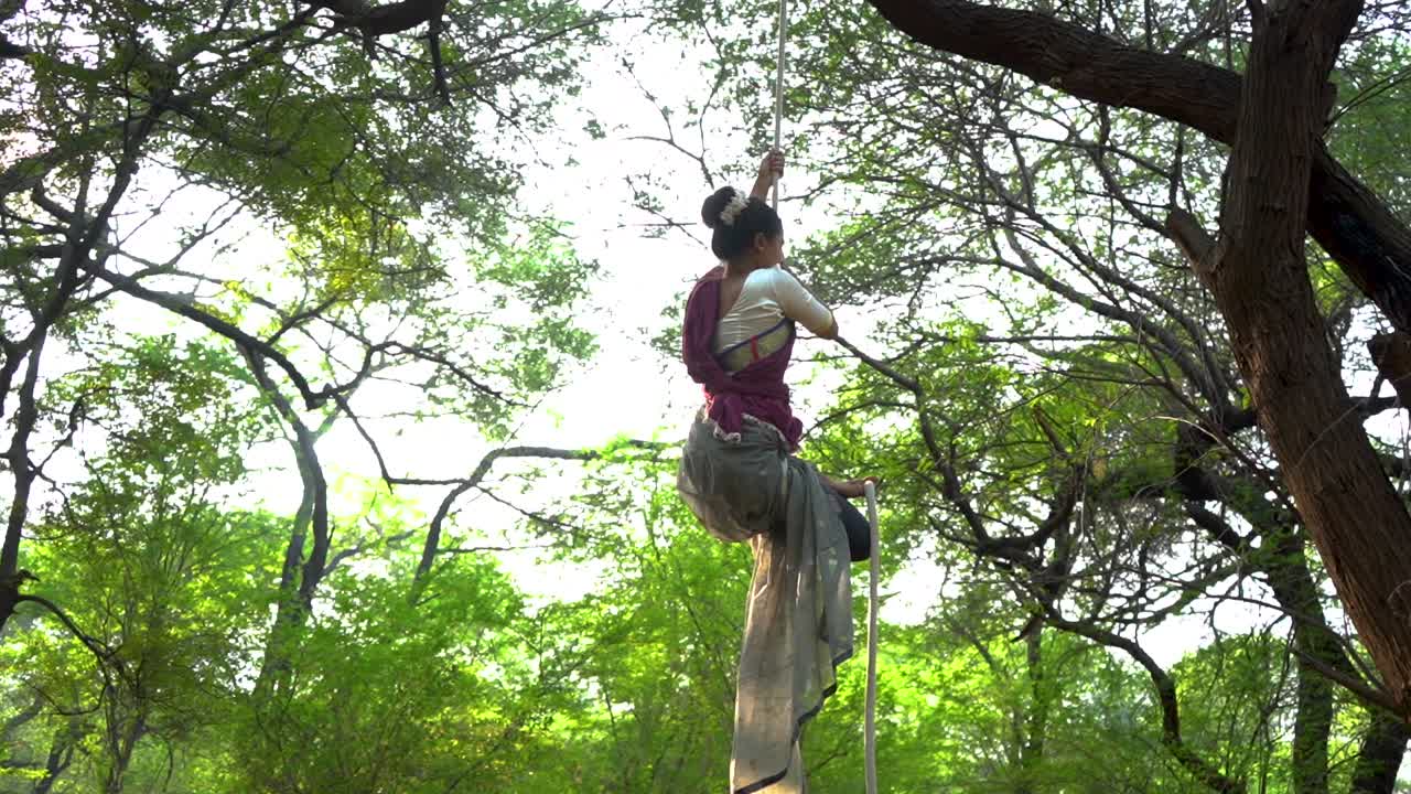 una gimnasta deportiva realiza ejercicios con una cuerda con ropa tradicional india