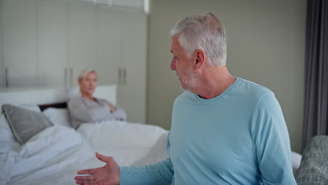 una pareja discutiendo en el dormitorio.