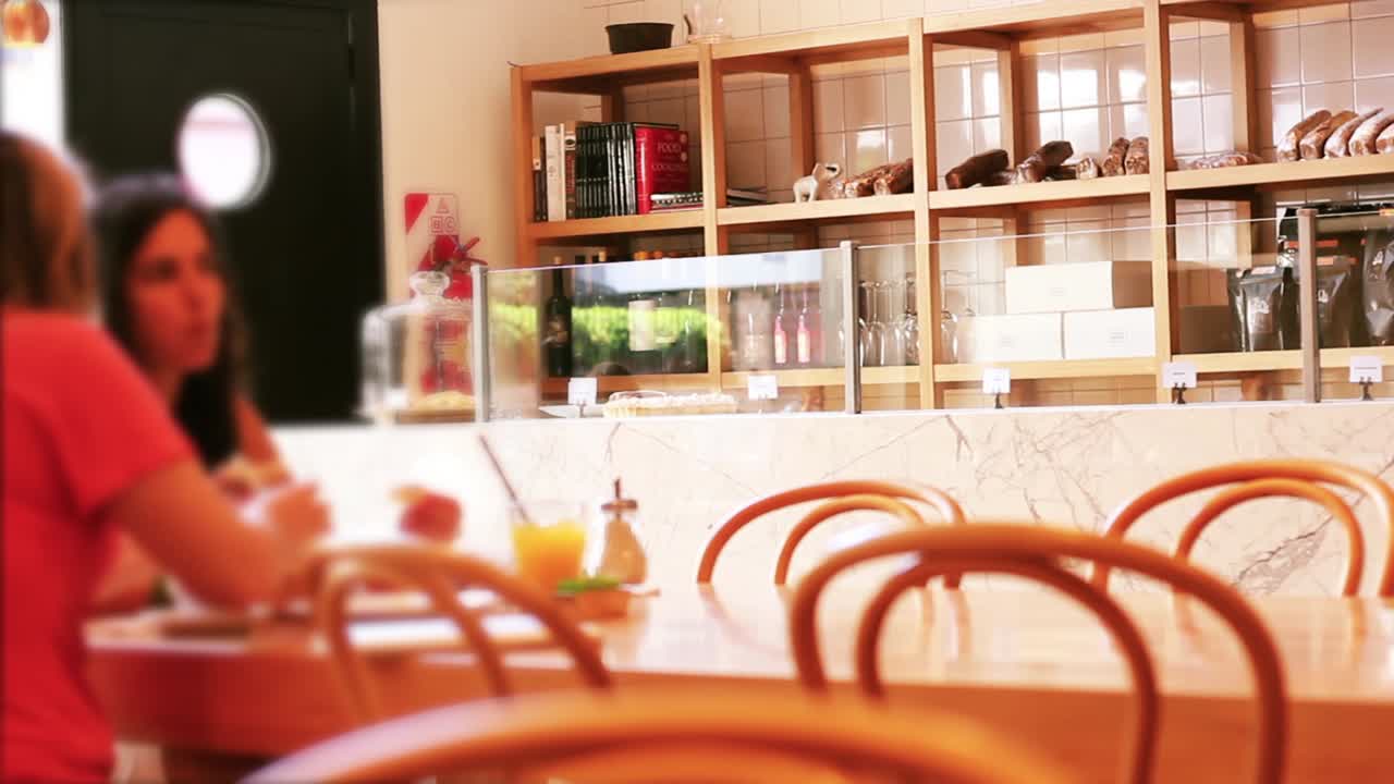 モダンなカフェまたはベーカリーで食事をするぼやけた人々。
