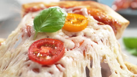 queso mozzarella derretido, tomates y albahaca encima de una rebanada de pizza margarita levantada con una espátula en macro y cámara lenta
