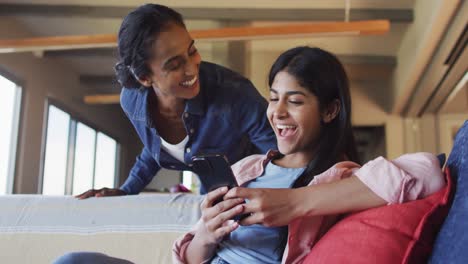 Video-of-happy-diverse-female-friends-using-smartphone-on-sofa