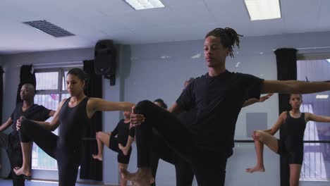 multi-ethnic group of fit male and female modern dancers practicing a dance routine