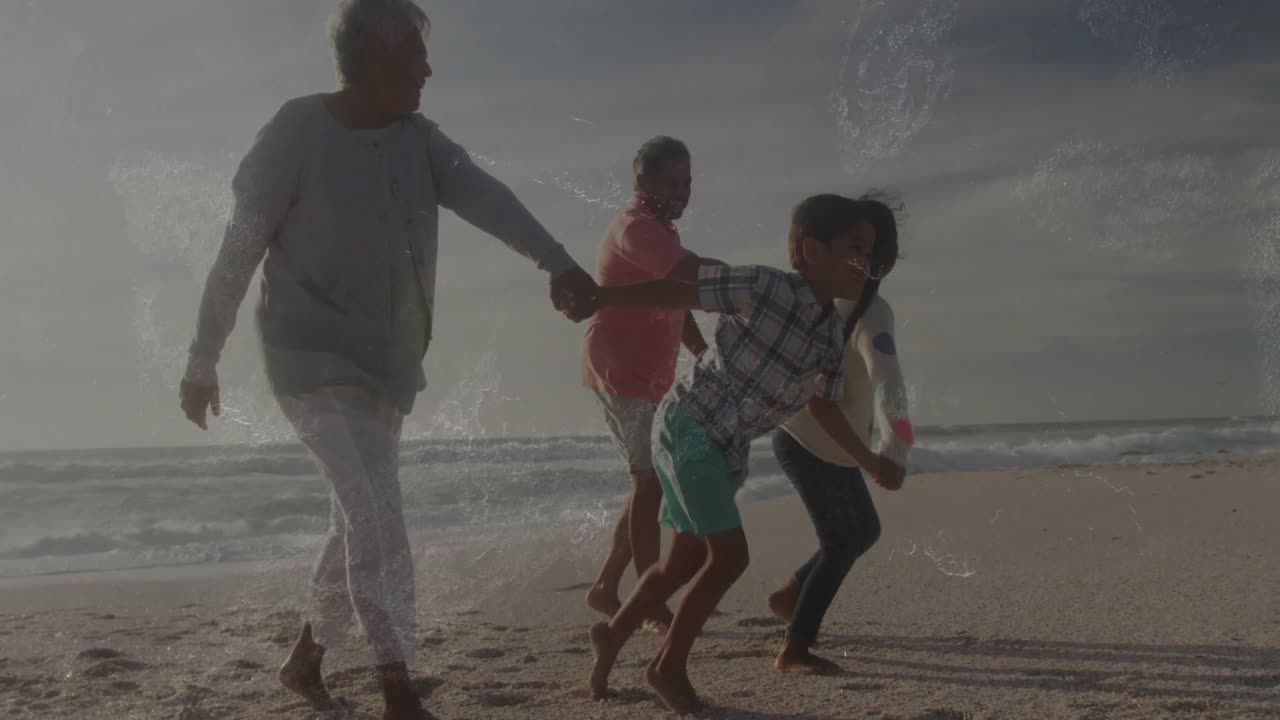 Older adult leaning forward initiating sprint pulling family by hands along sandy beach for travel