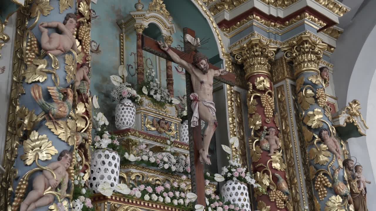 Kruzifix, das Jesus Christus am Kreuz mit vergoldetem Altar und Skulpturen zeigt.