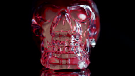 red and blue skull face illuminated on black background, dolly shot