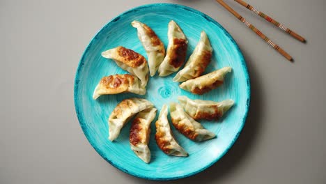 albóndigas asiáticas tradicionales gyozas en plato de cerámica turquesa