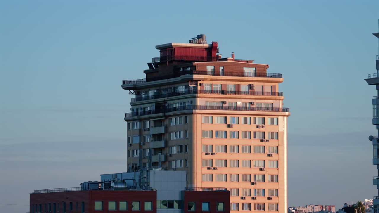 Urban residential tower with warm light reflections at sunset