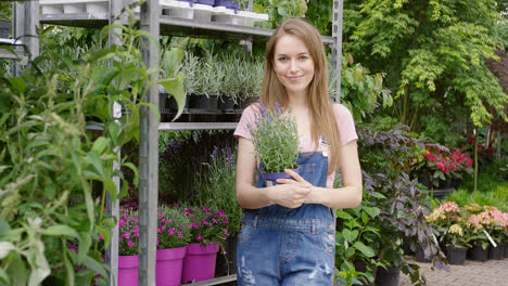 Young-pretty-gardener-woman-posing-at-stand-with-potted-flowers