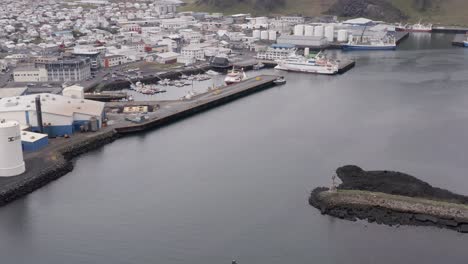 Boat-travels-into-island-inlet-harbor-creating-v-shaped-ripple-on-water-surface