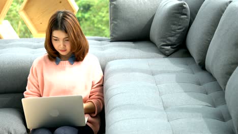 attractive asian woman enjoy relaxing time with laptop in living room home background