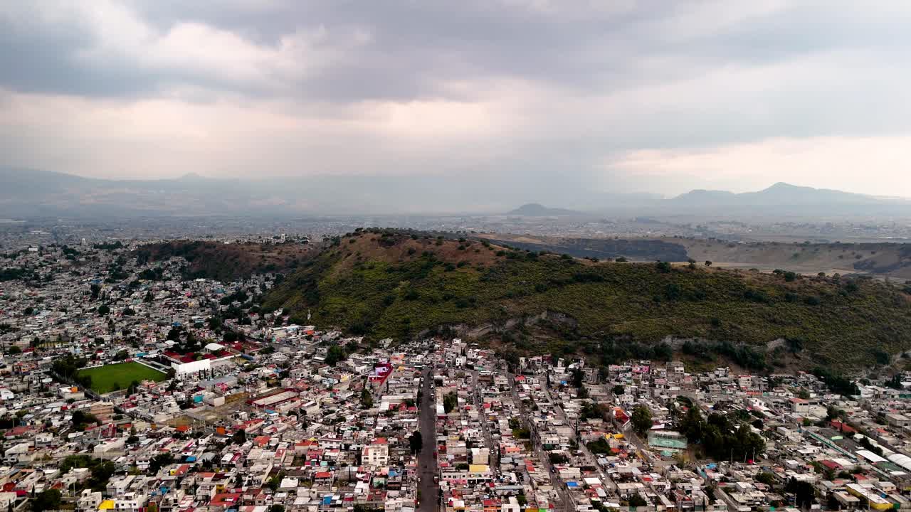 Plano lateral con dron del deterioro urbano en Ciudad de México en un volcán