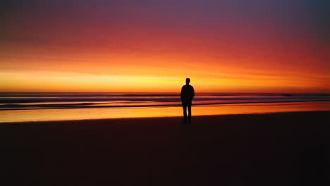silhouette of a person on a beach at sunset