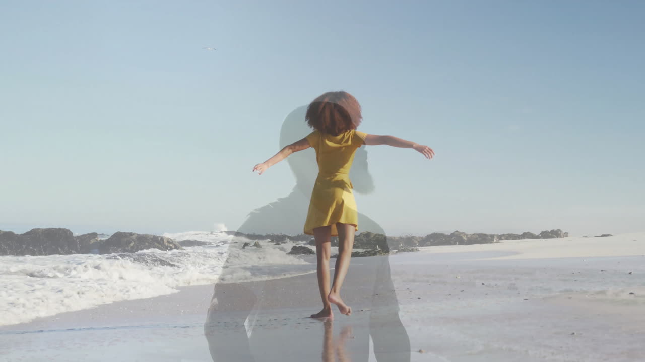 woman dancing barefoot on shoreline, showing translucent silhouette with yellow dress for marketing