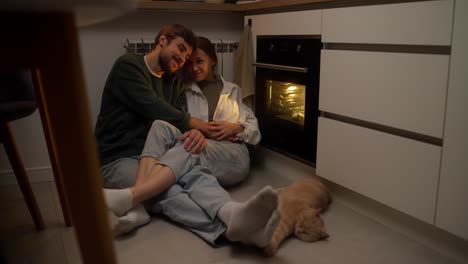 una pareja relajándose en la cocina por la noche.