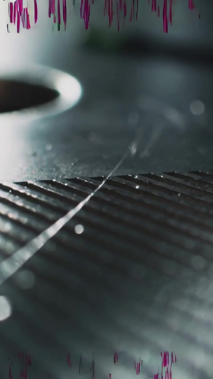 Vertical video: Shifting camera revealing ribbed griddle in kitchen, showing droplets and scrapes