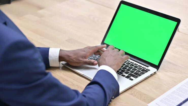 African Man Working on Laptop with Chroma Screen