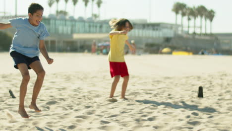 Niño-Feliz-Marcando-Gol-Mientras-Juega-Fútbol-Con-Un-Amigo-En-La-Playa