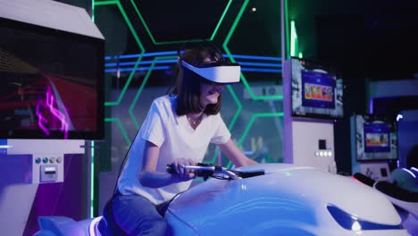 woman experiences virtual reality motorcycle ride in an arcade