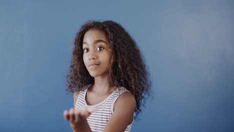 Fröhliches-Afroamerikanisches-Mädchen-Mit-Gebärdensprache-Auf-Blauem-Hintergrund,-Zeitlupe