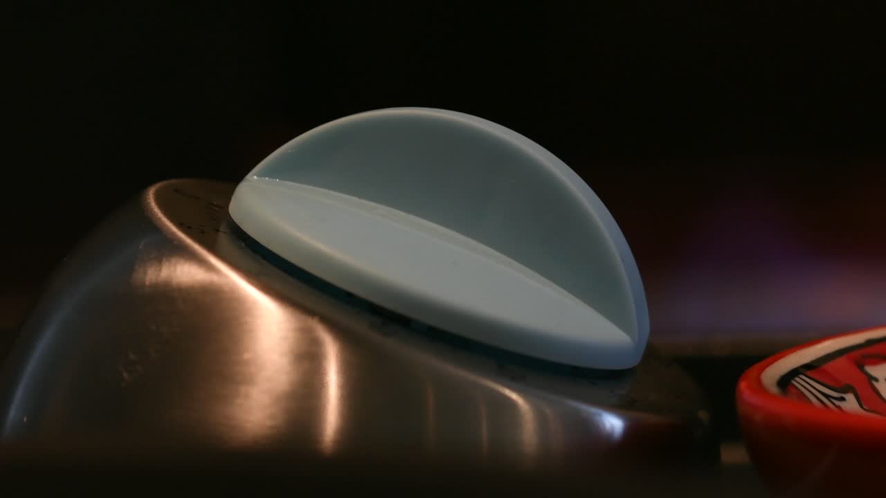 temporizador de huevo de cocina en primer plano con llama ardiente de la estufa en el fondo