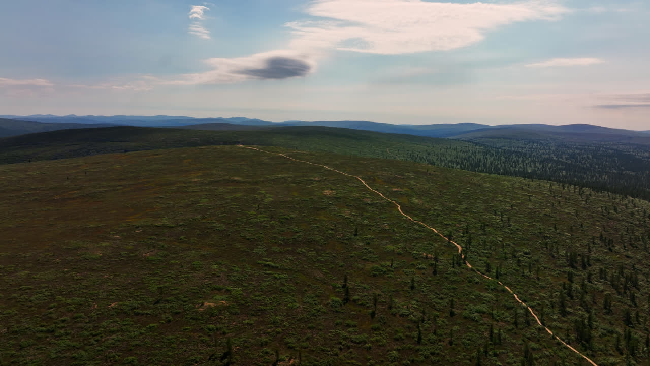 drone dando vueltas en un sendero de tierra en la cima de las montañas en el parque nacional ukk, en finlandia