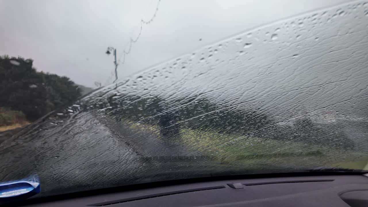 Car windshield with rain during gloomy weather