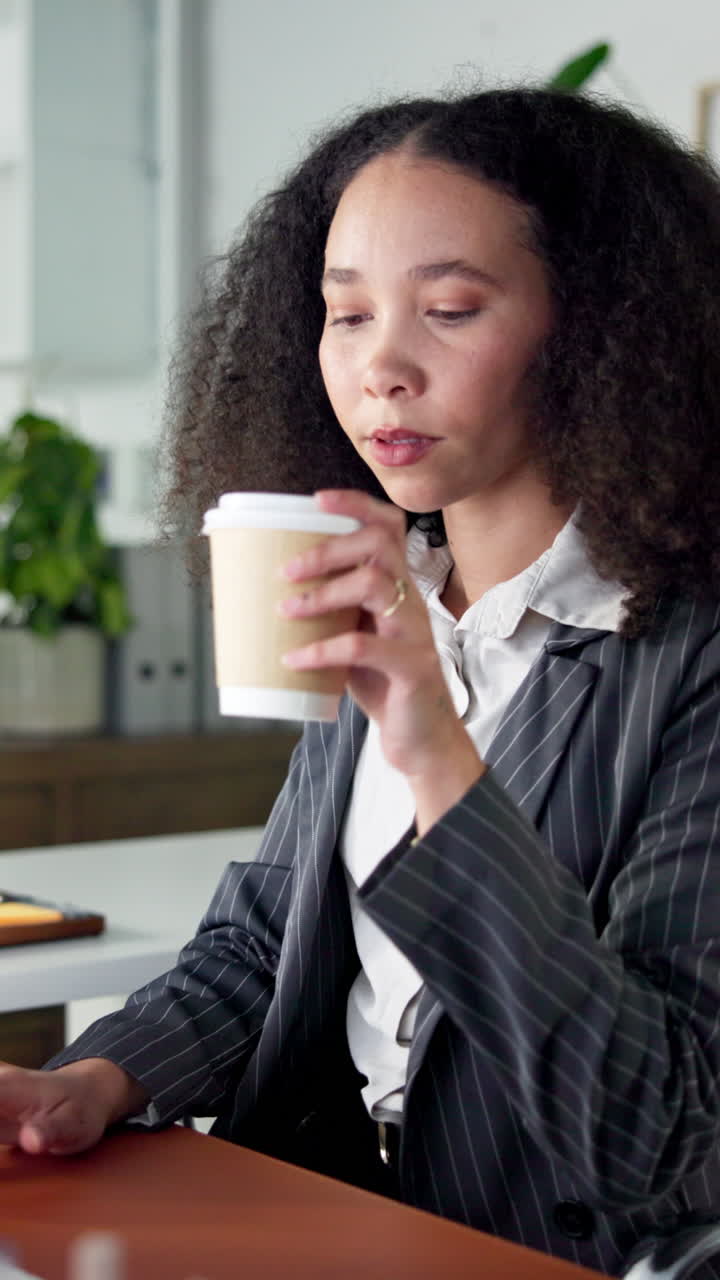 Ung forretningskvinde drikker kaffe og arbejder på kontoret