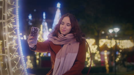 girl takes a selfie with her smartphone at a christmas market medium slow motion gimbal shot