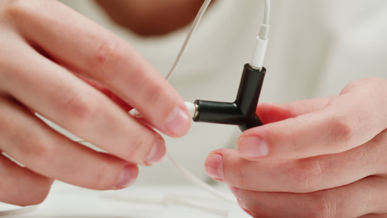 Hands connecting headphones