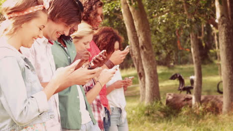 In-Zeitlupe-Glückliche-Freunde-Im-Park-Mit-Ihren-Handys-