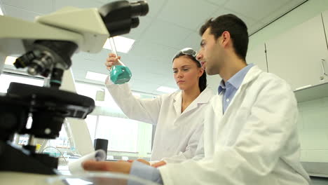 Estudiantes-De-Ciencias-Mirando-Juntos-La-Sustancia-Química-Azul