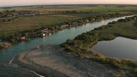 aerial shot of the valleys near ravenna where the river flows into the sea with the typical fishermen's huts