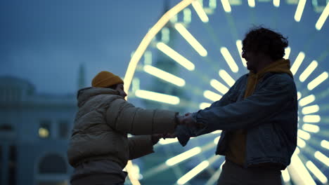 happy couple holding hands on street. man and woman dancing in city center.