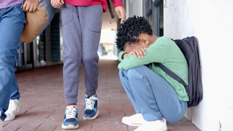 in school, child sitting on ground with head down, feeling sad or upset